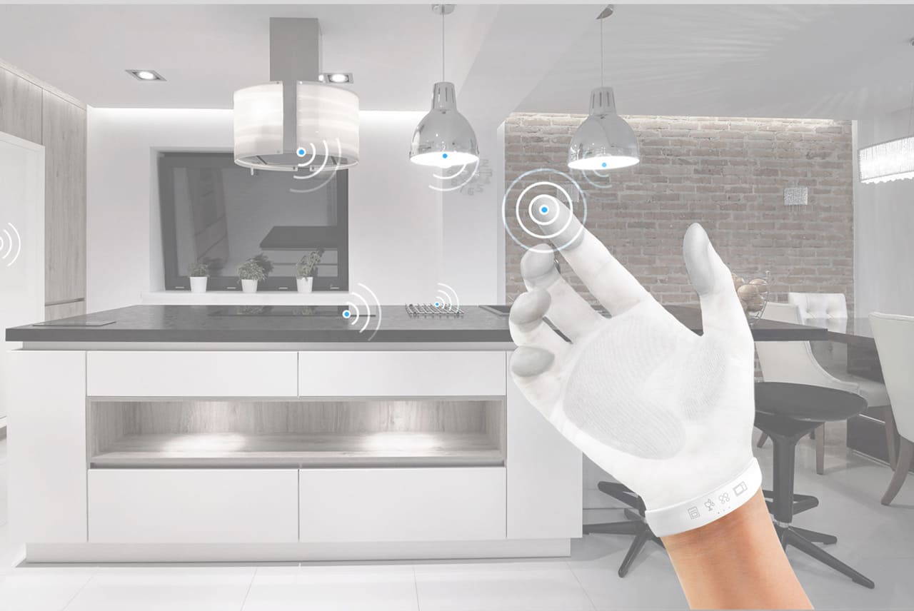 Smart gesture-control glove in the foreground and signal markers on connected appliances in the kitchen background.